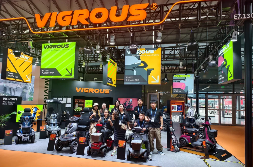 A group photo of the VIGROUS team, a leading mobility scooter vendor, showcasing their commitment to quality and service at their trade show booth.
