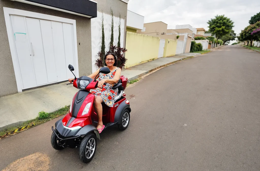 Senior woman riding the Vista Scooter on a neighborhood street