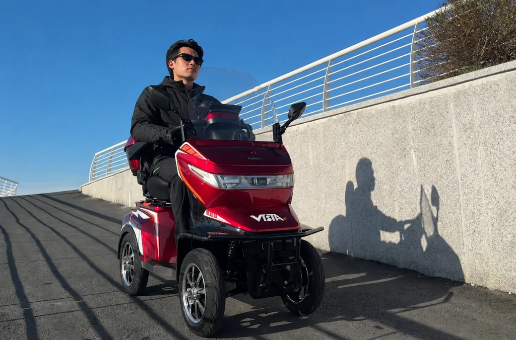 What Makes the Vista-4E 4 Wheel Electric Scooter Different? 9 Outdoor riding demonstration of the open-top Vista-4E 4 wheel electric scooter handling a downhill slope with stability.